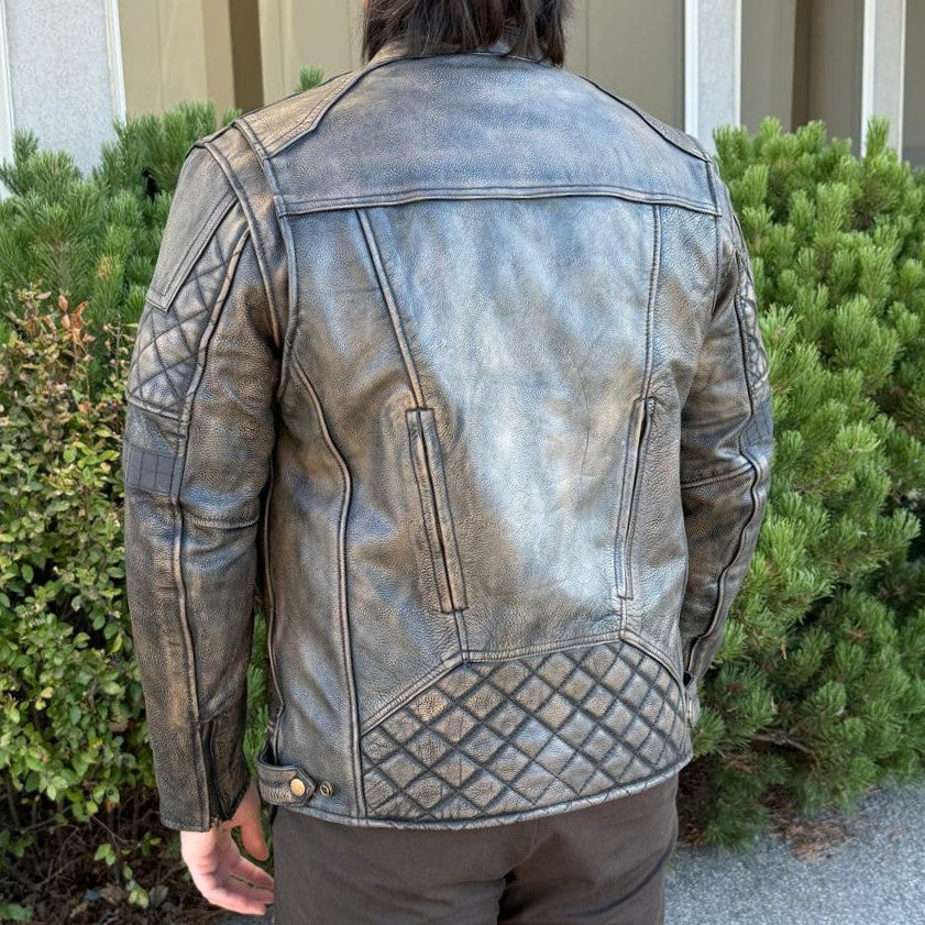 A man wearing a distressed brown leather motorcycle jacket with geometric diamond-stitch detailing on the shoulders