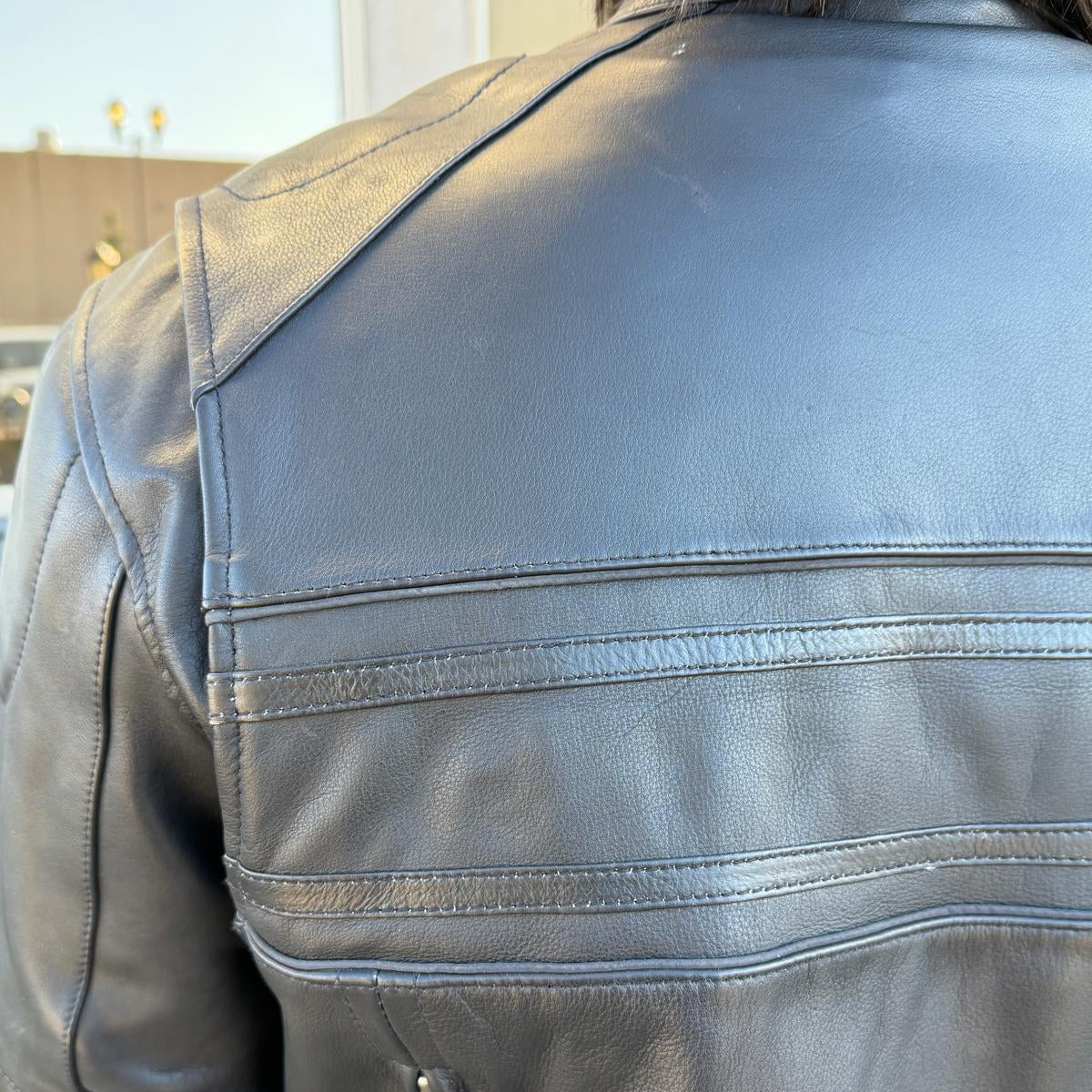 A man wearing a black leather motorcycle jacket