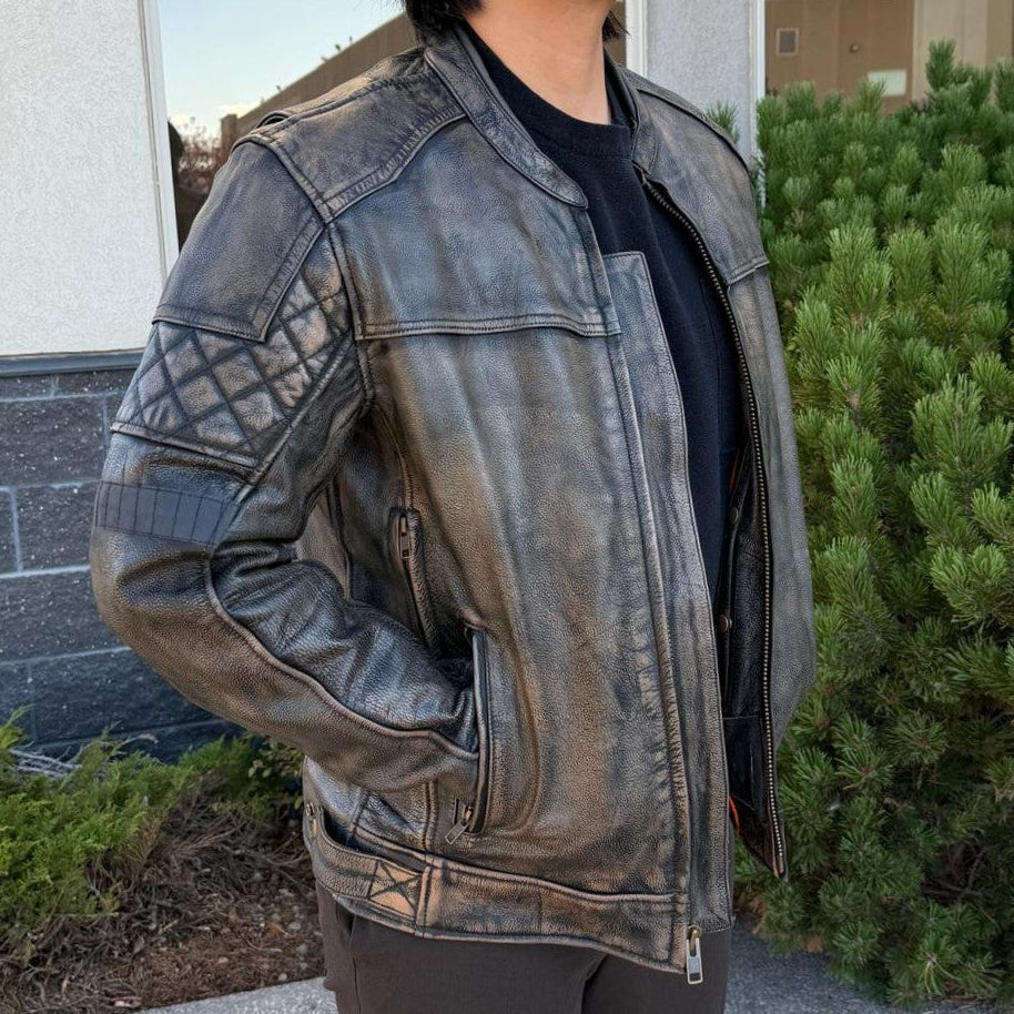 A man wearing a distressed brown leather motorcycle jacket with geometric diamond-stitch detailing on the shoulders