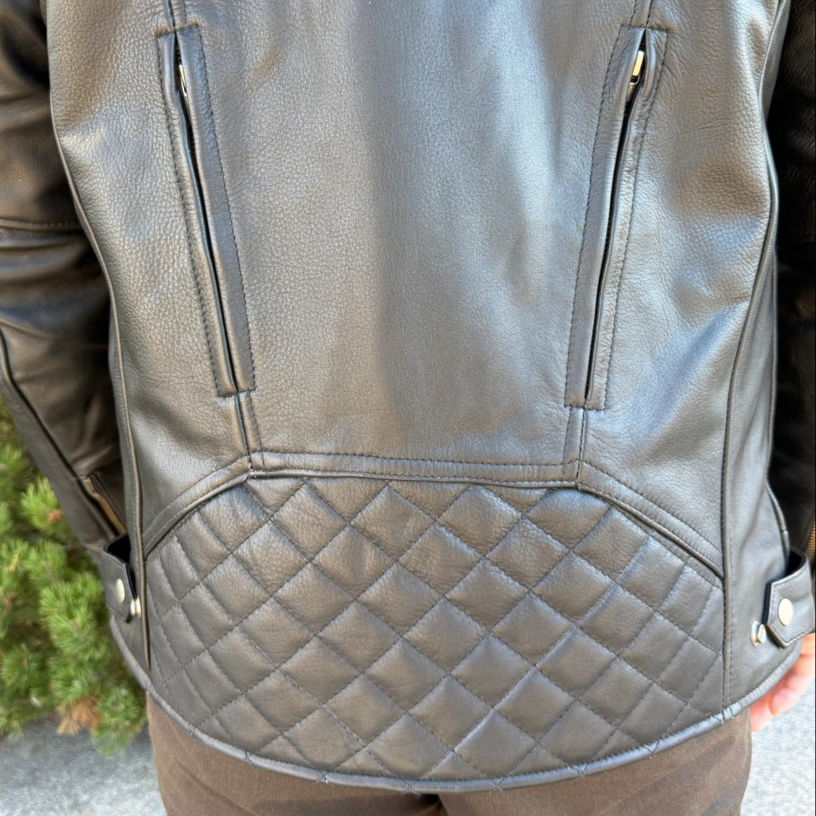 A man wearing a black leather motorcycle jacket