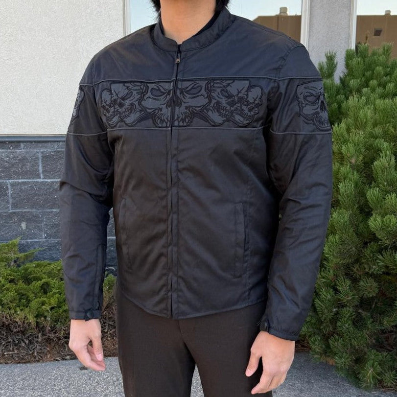 A man wearing a black bomber motorcycle jacket with intricate black embroidery across the chest