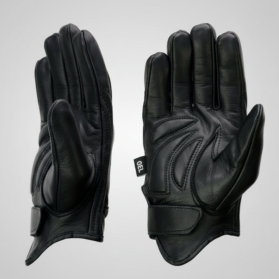Pair of black leather gloves with gel palm and reflective material on a beige background