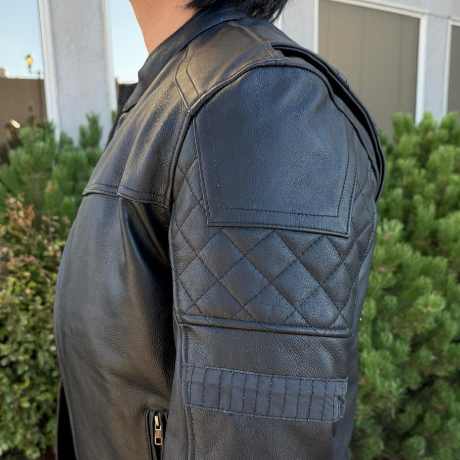 A man wearing a black leather motorcycle jacket