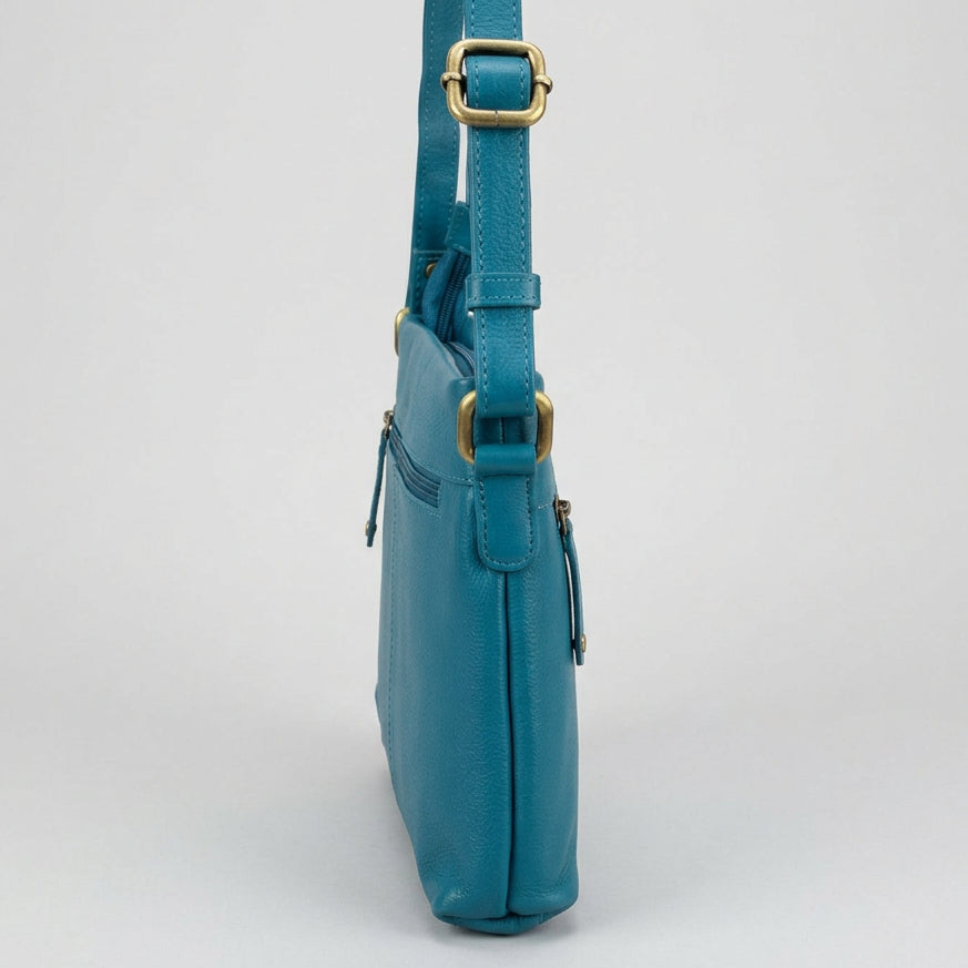 A turquoise blue leather crossbody bag with gold-tone hardware