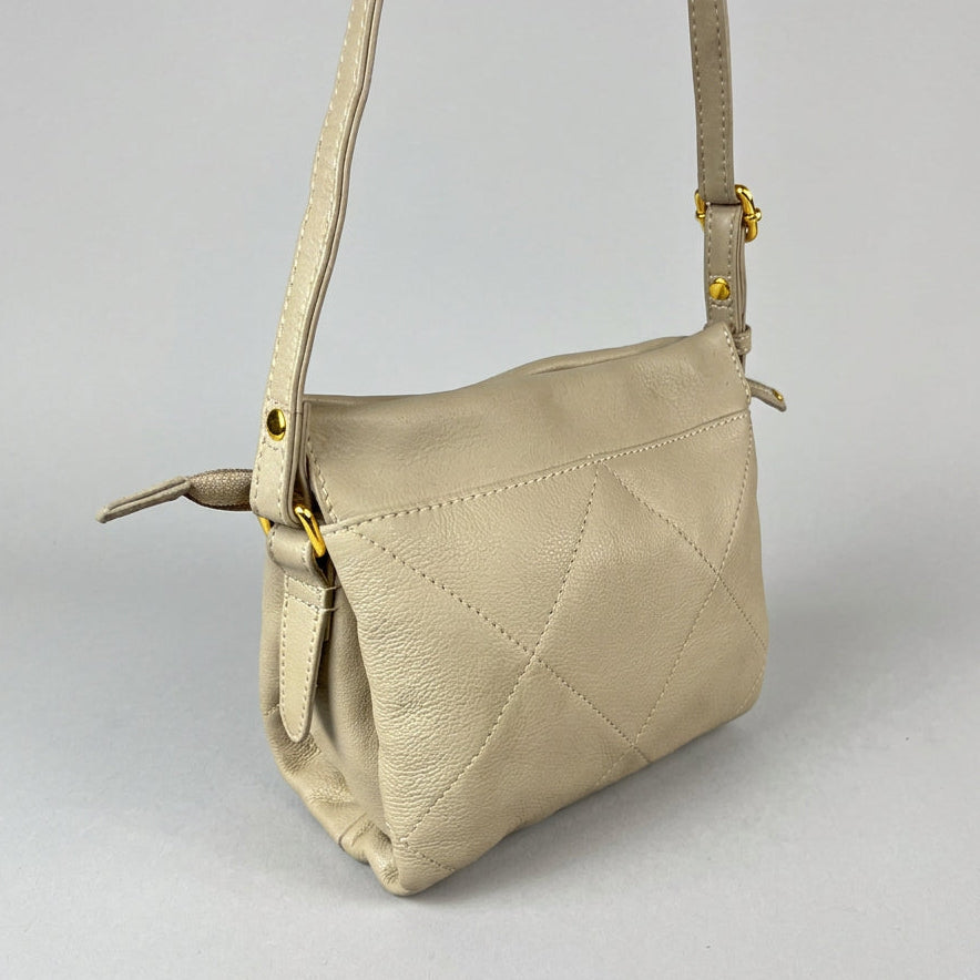 A light beige leather crossbody bag with a diamond-quilted pattern and a single strap