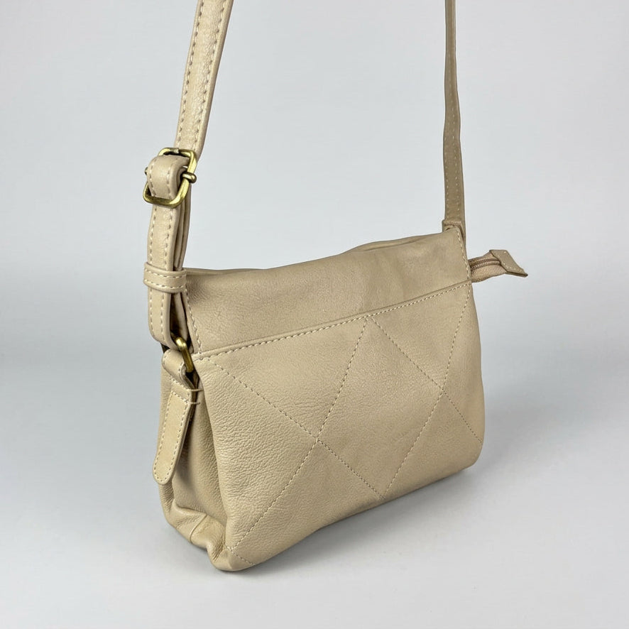 A light beige leather crossbody bag with a diamond-quilted pattern on the front flap