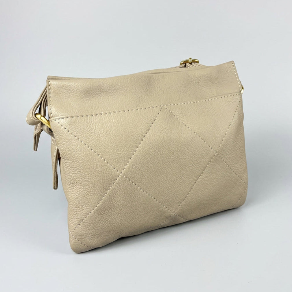 A cream-colored pebbled leather clutch bag with a diamond-quilted pattern and gold-tone hardware