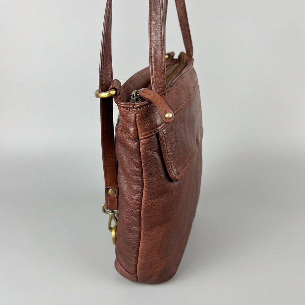 A brown leather shoulder bag with brass hardware