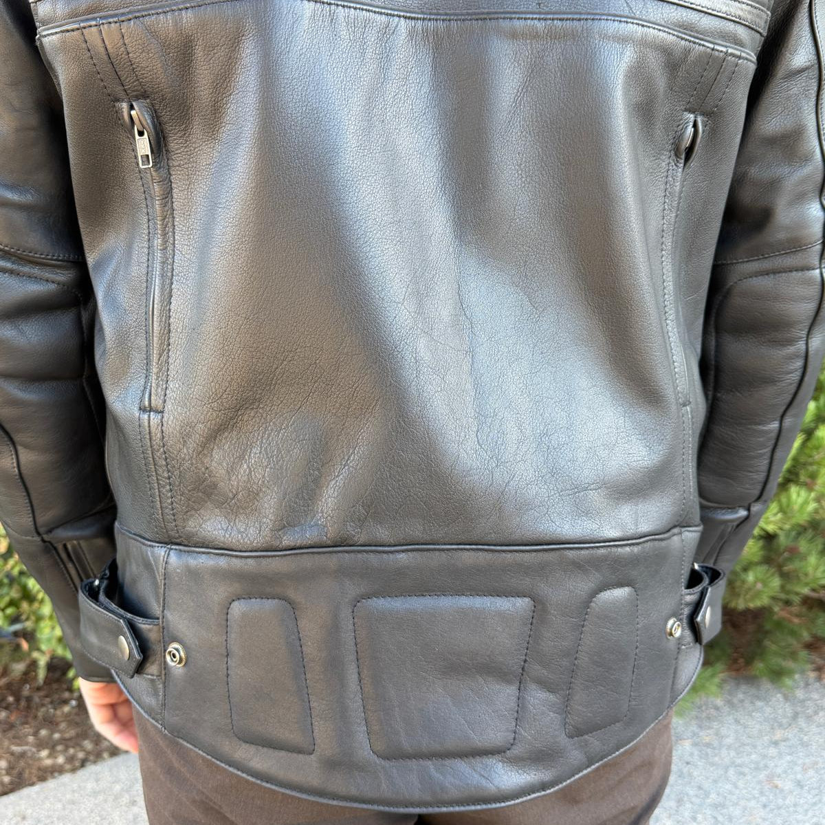 A man wearing a black leather motorcycle jacket