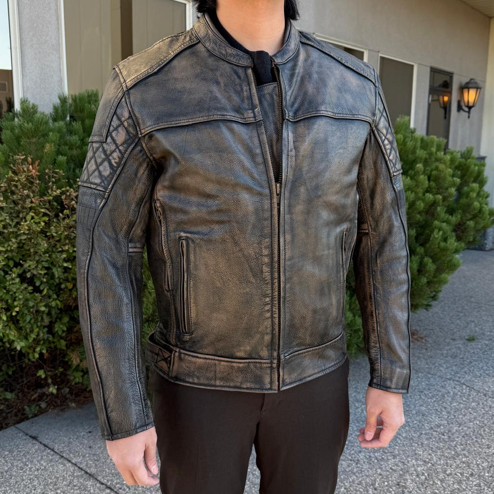 A man wearing a distressed brown leather motorcycle jacket with geometric diamond-stitch detailing on the shoulders