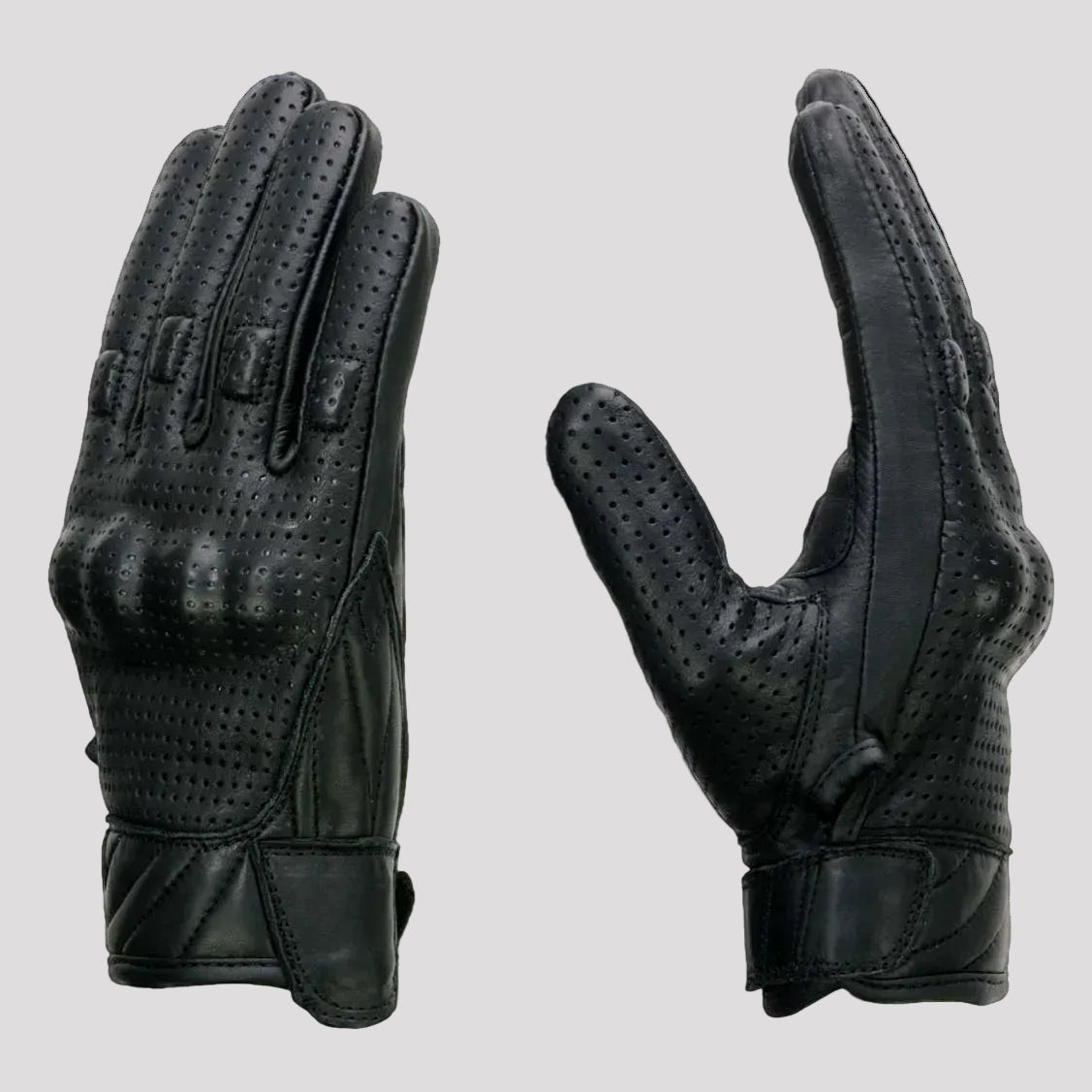 Black leather gloves with palm padding and knuckle protection on a beige background