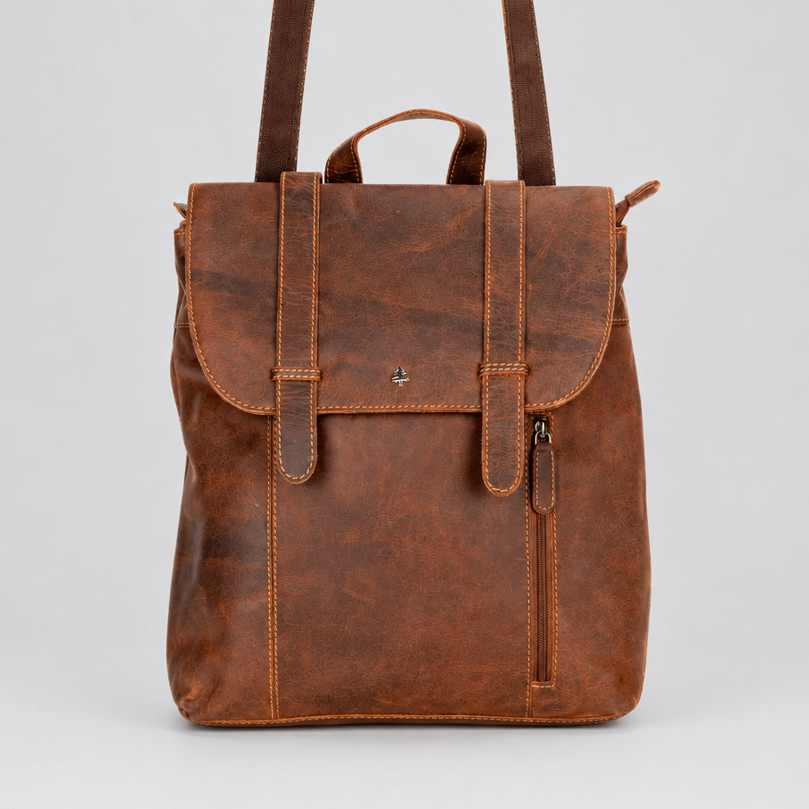 A brown distressed leather backpack with a top handle, front flap pocket, and side zipper