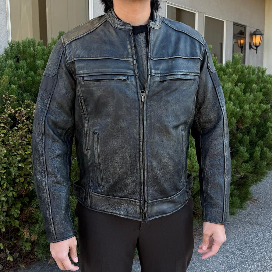 A man wearing a distressed brown leather motorcycle jacket