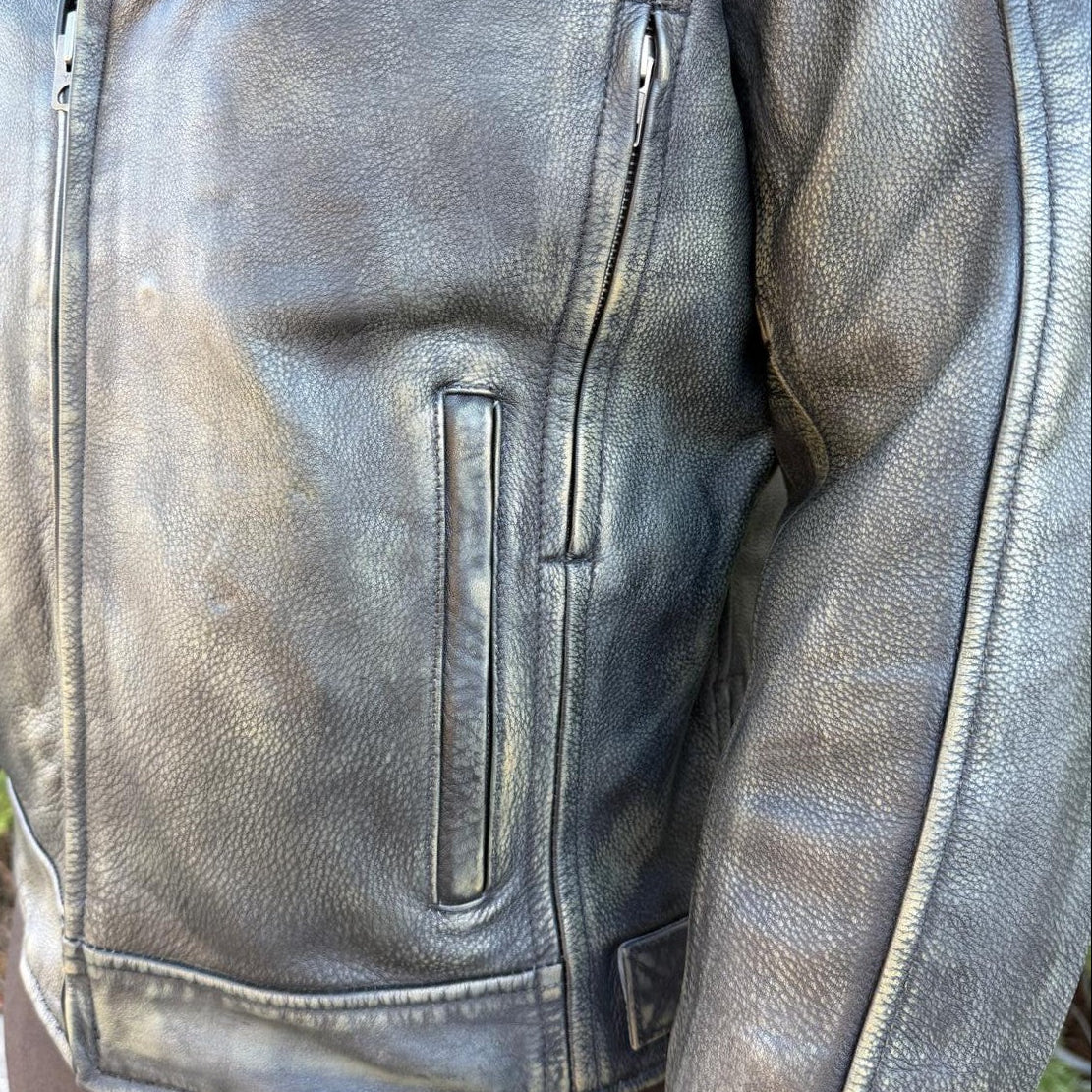 A man wearing a distressed brown leather motorcycle jacket
