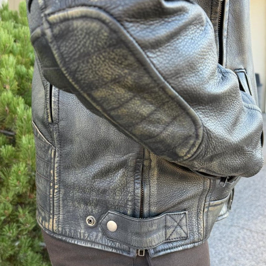 A man wearing a distressed brown leather motorcycle jacket