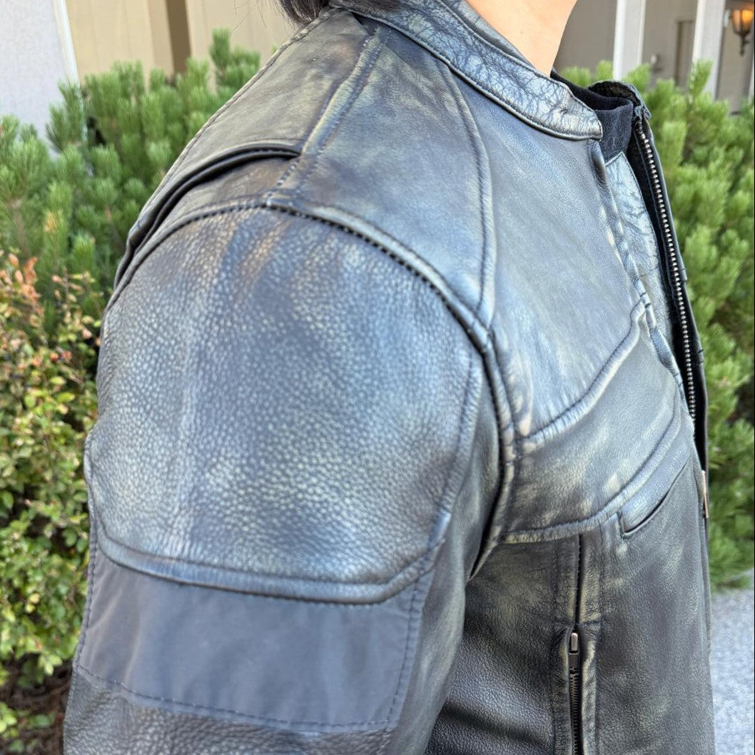 A man wearing a distressed brown leather motorcycle jacket