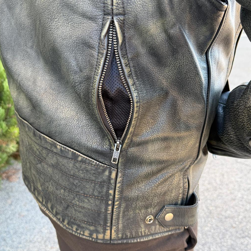 A man wearing a distressed brown leather motorcycle jacket