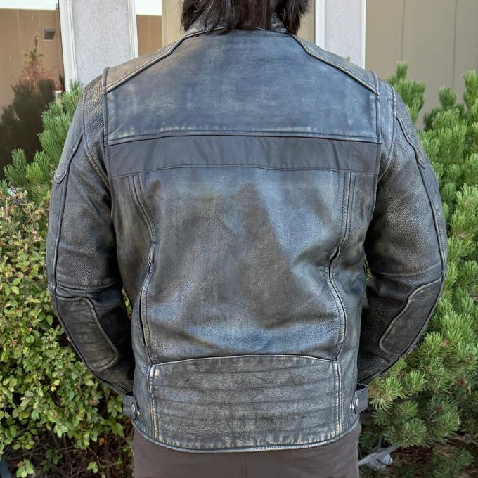 A man wearing a distressed brown leather motorcycle jacket