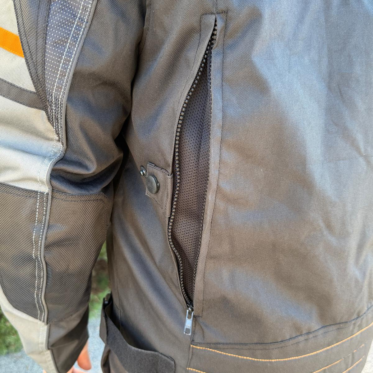 A man wearing a black and gray motorcycle jacket with reflective gray stripes