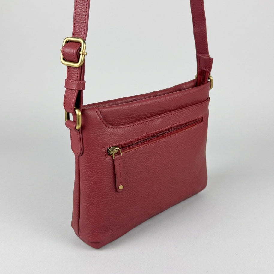 A burgundy pebbled leather crossbody bag with gold-tone hardware