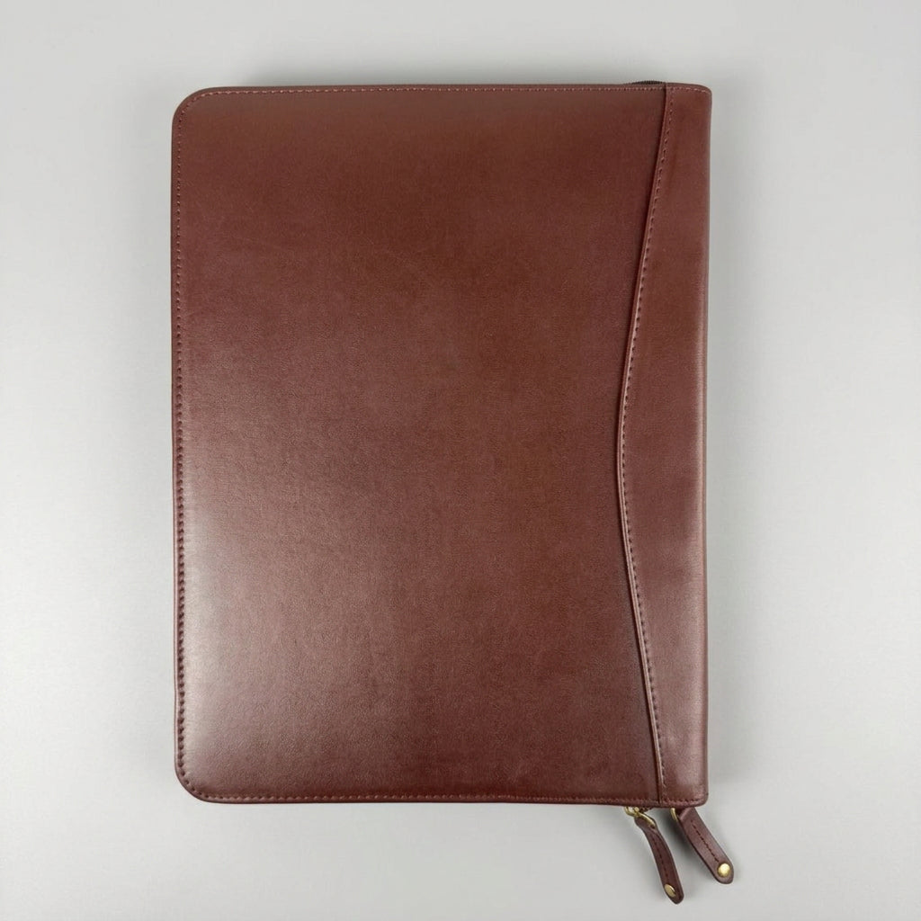 A brown leather planner cover or notebook sleeve with a diagonal flap detail
